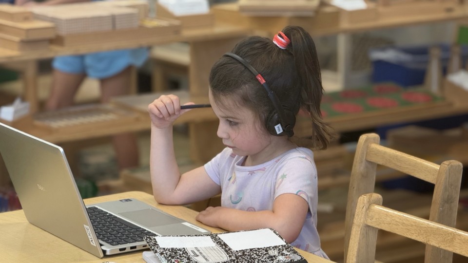 Young student focused on laptop learning with headphones