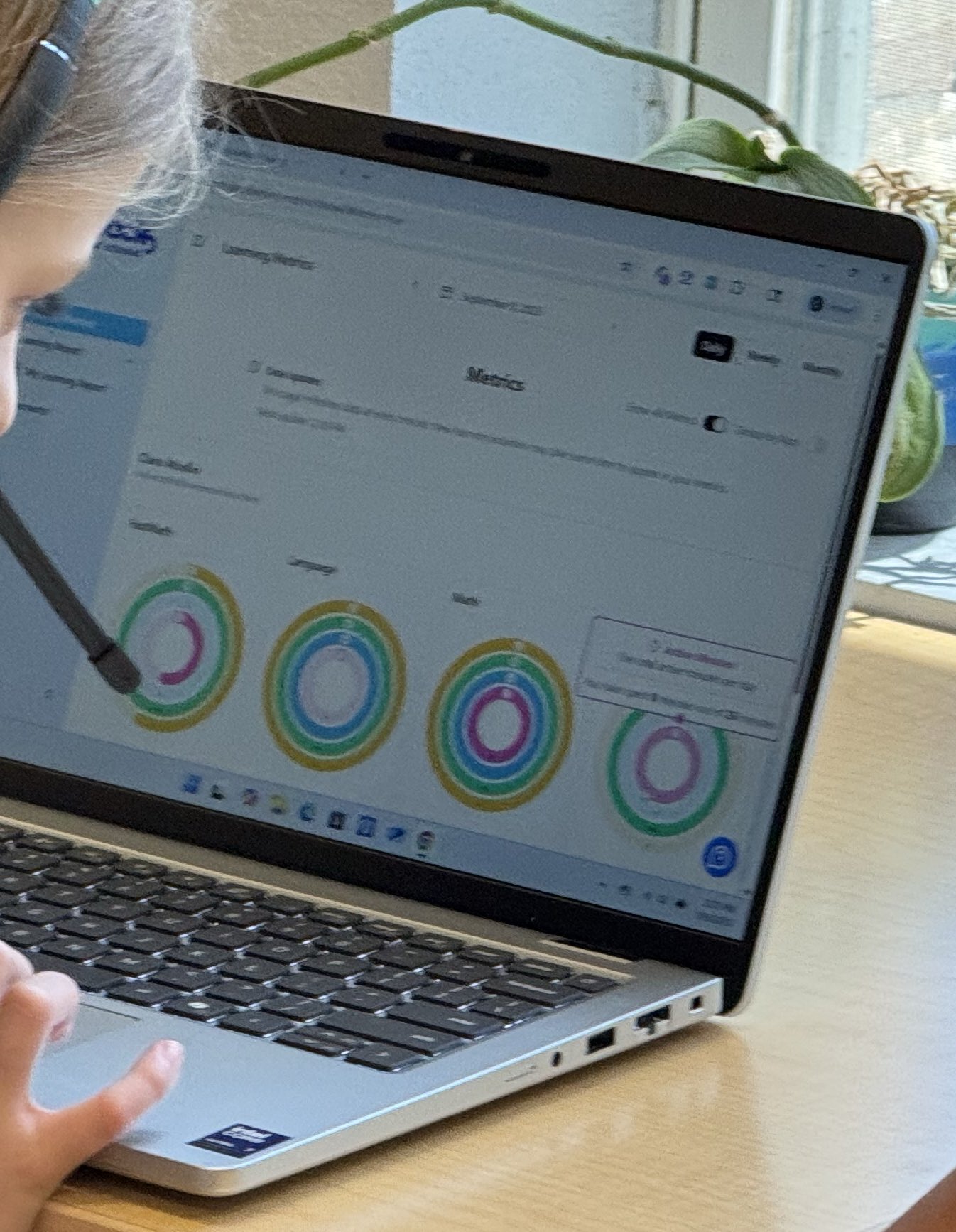 Student reviewing learning metrics and progress rings on laptop
