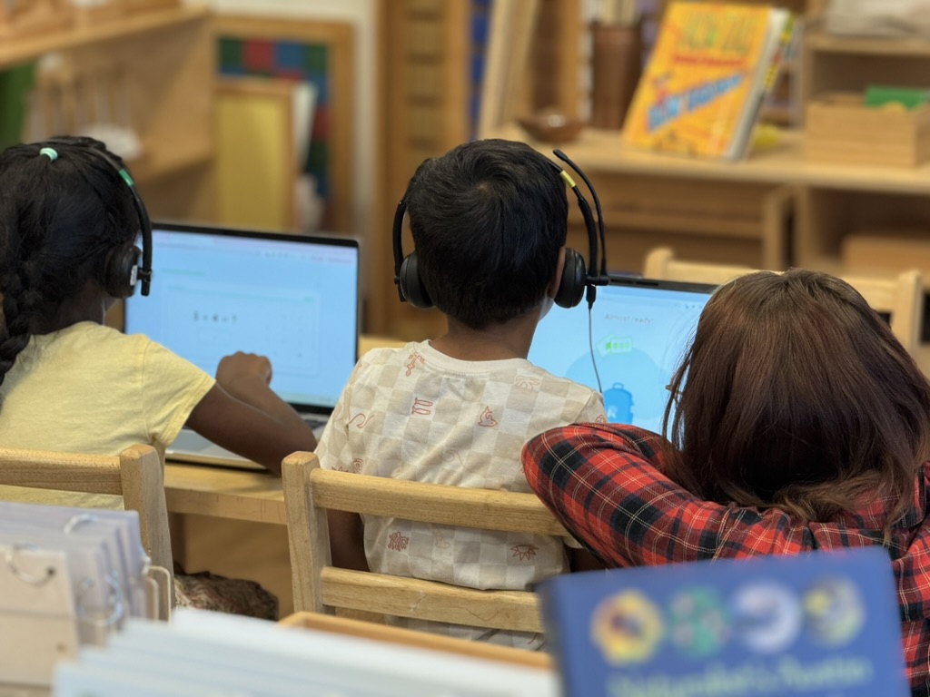 Three students working together on laptops in the classroom